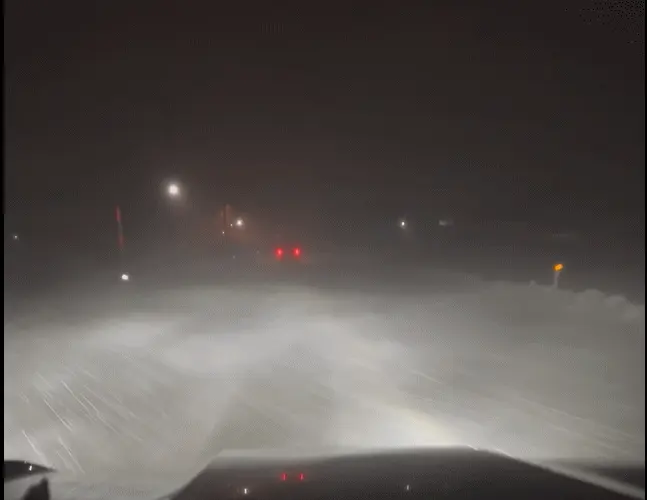 地吹雪の中、国道まで先導してくれる車の赤いテールランプが前方に見える