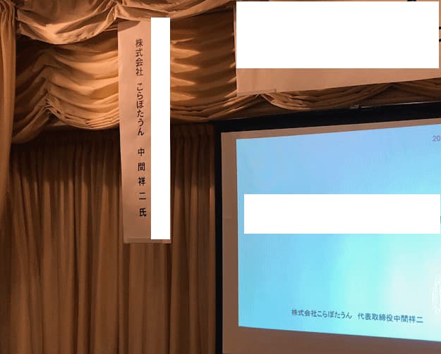 共創マーケティング講演時の演台とスクリーンの様子