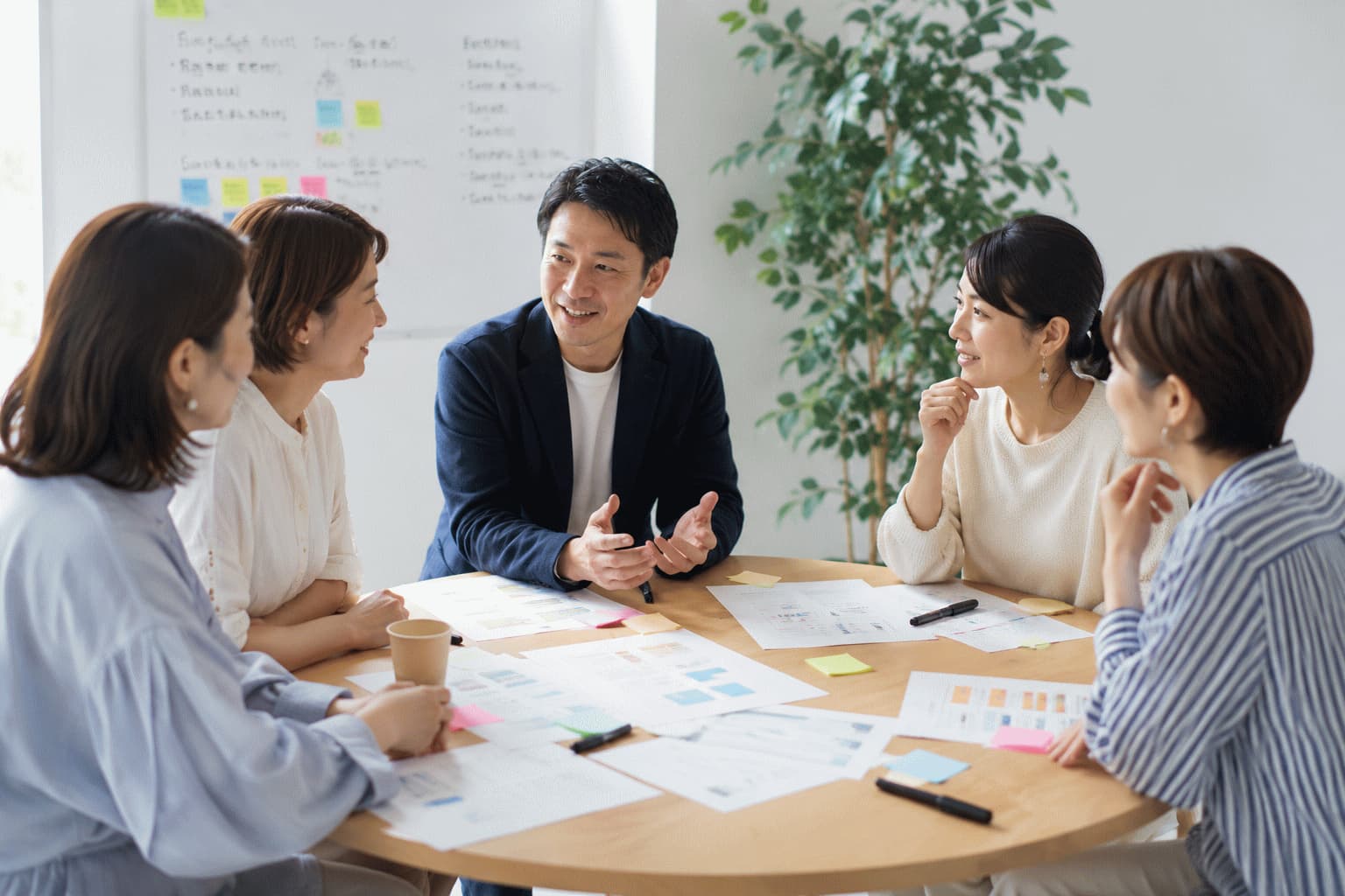企業担当者と生活者が丸テーブルを囲み、資料を見ながら対話している共創セッションの様子