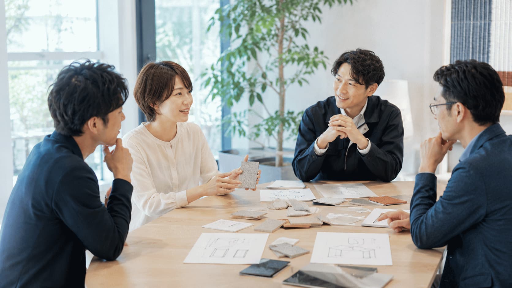 参加者が家族や友人との会話から生まれた新素材の使い道を、カードやスケッチを使いながら企業担当者へ共有している様子