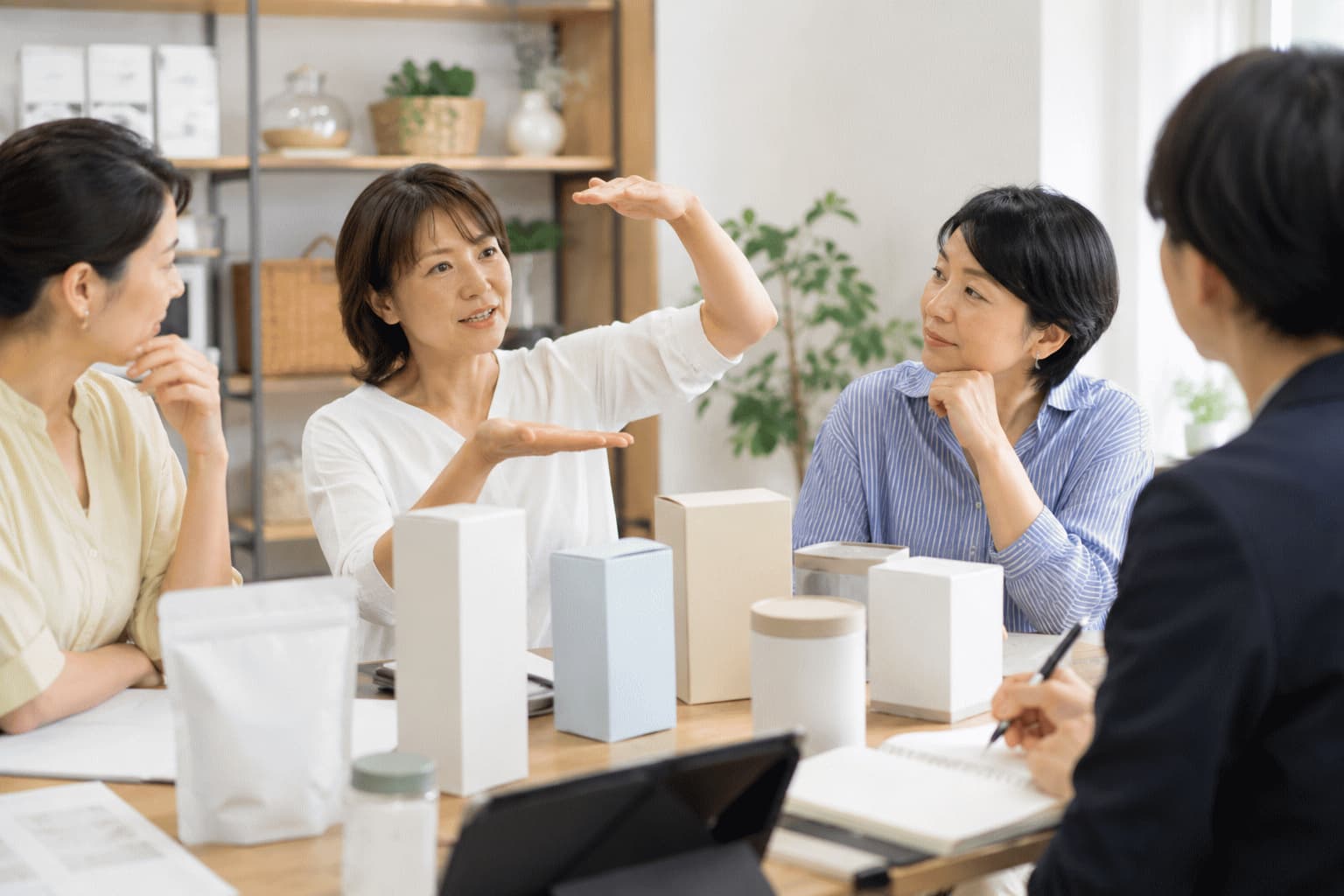 主婦を中心とした生活者が商品を見ながら、自宅の棚や収納場所に入るかを企業担当者と話し合っている様子