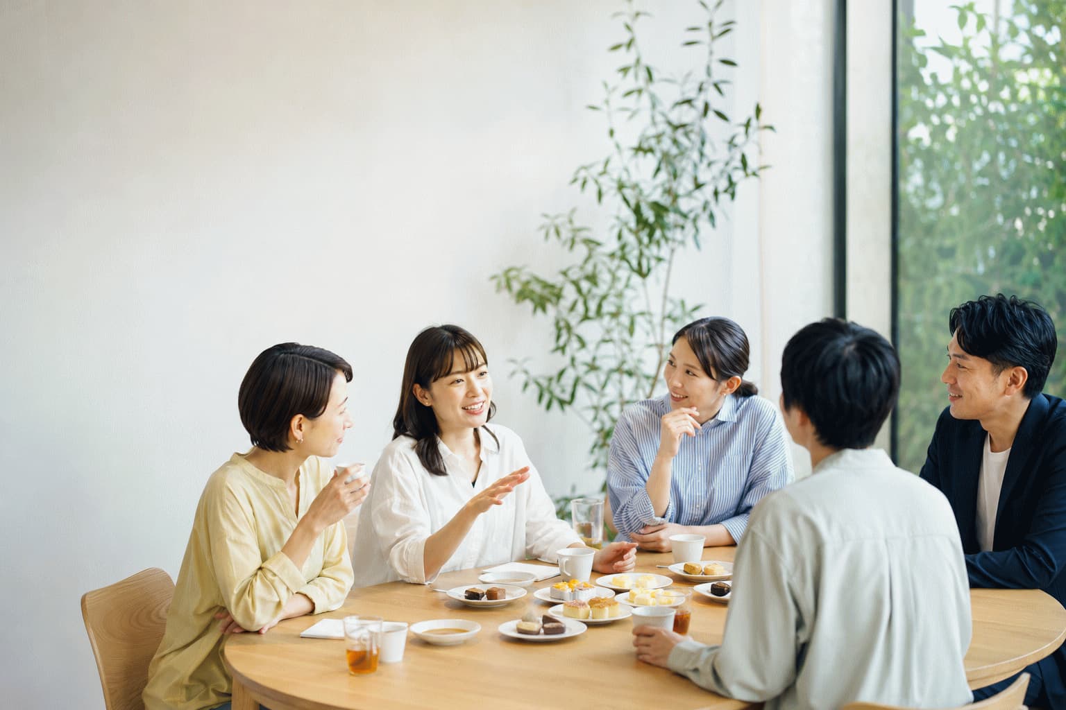 生活者と企業担当者が丸テーブルを囲み、試食や試飲をしながら自由に会話している様子
