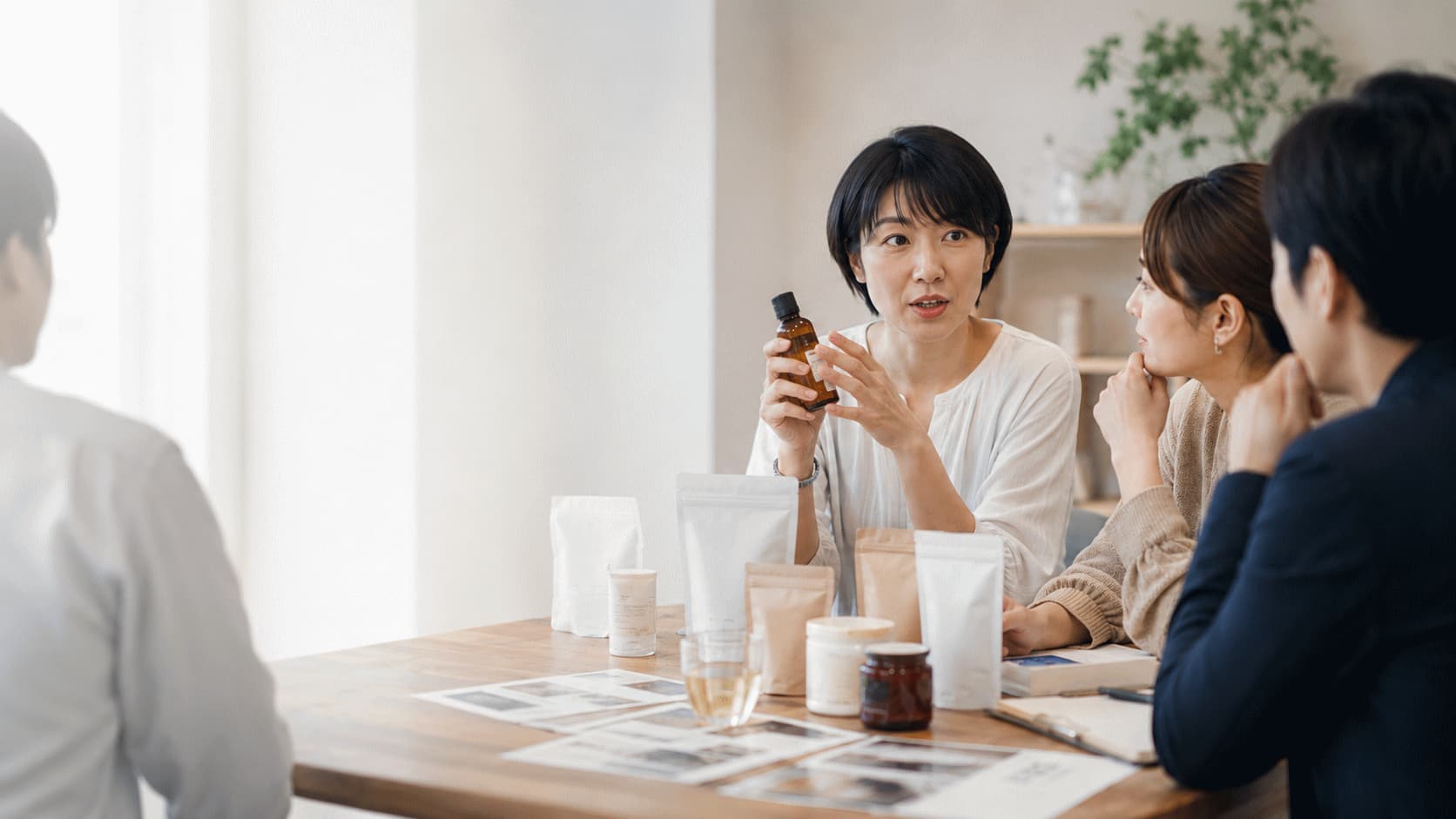 生活者と企業担当者が丸テーブルを囲み、商品の背景やつくり手の工夫について話している様子